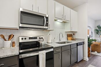 A modern kitchen with a black stove top oven and a microwave above it
